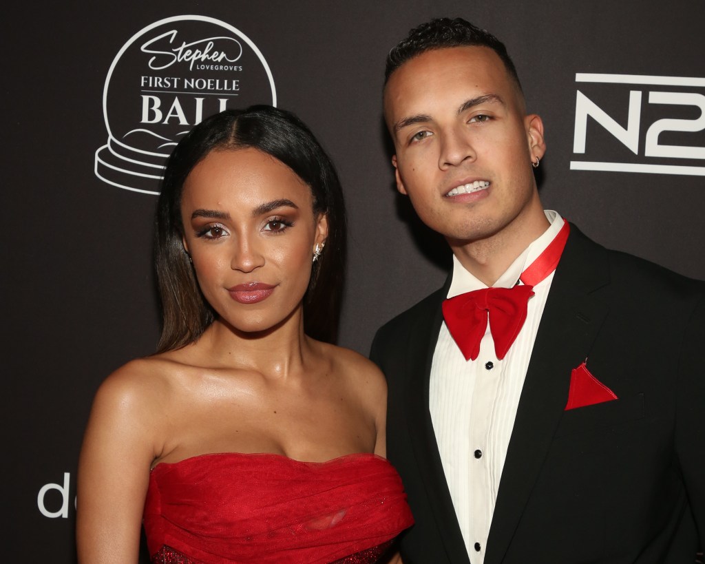 Serene Russell wearing a red dress and posing with Brandon Jones, who is wearing a black tuxedo with red accessories.