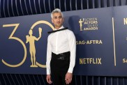 Tan France in a white blouse and black pants posing at the 30th annual SAG awards