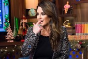 Kyle Richards in a black blazer, she is biting her finger on the set of Watch What Happens Live