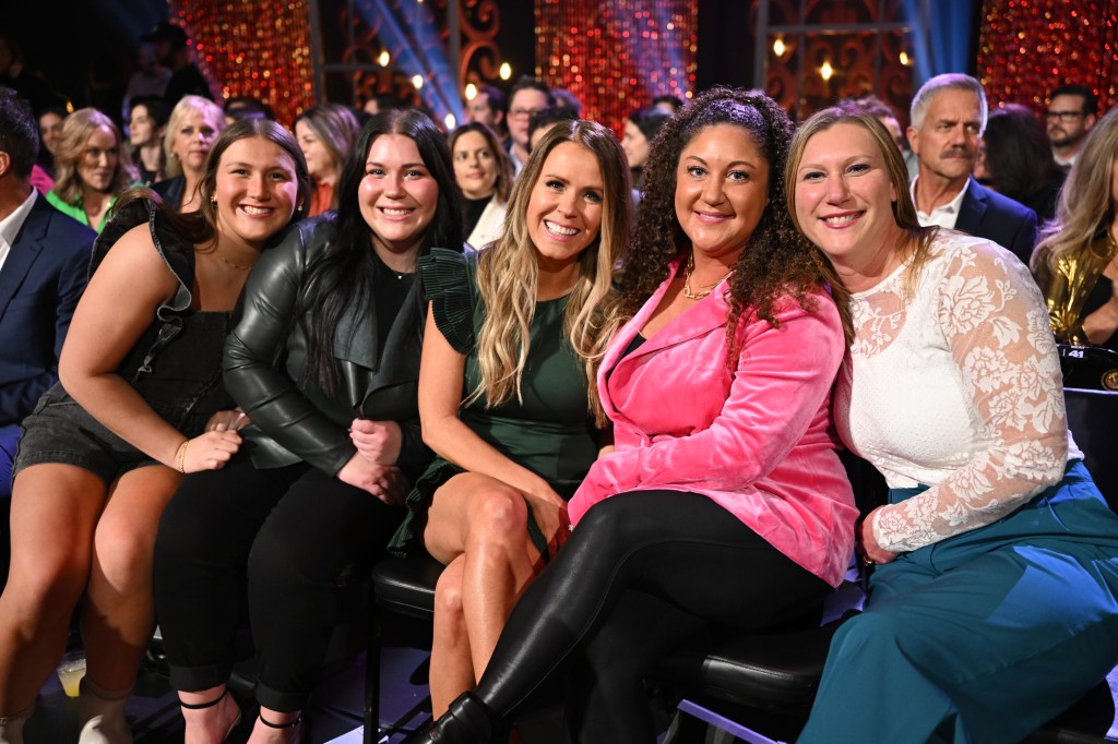 Angie Turner in a pink suit sitting with Gerry Turner and Theresa Nist's families on the Golden Bachelor live finale