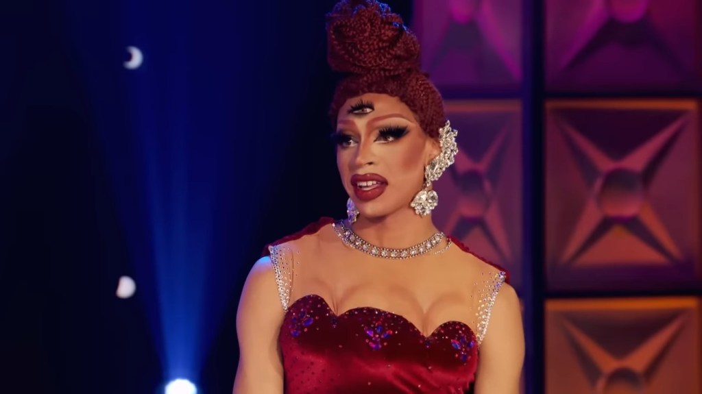 Yvie Oddly in a red dress on Season 11 of Drag Race with three eyes