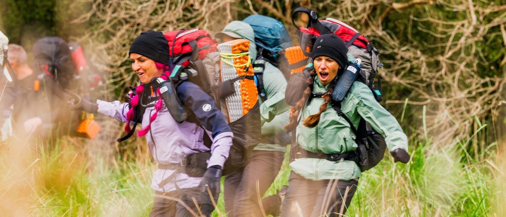 Rhandi and Ashley racing through a field on Race to Survive: New Zealand