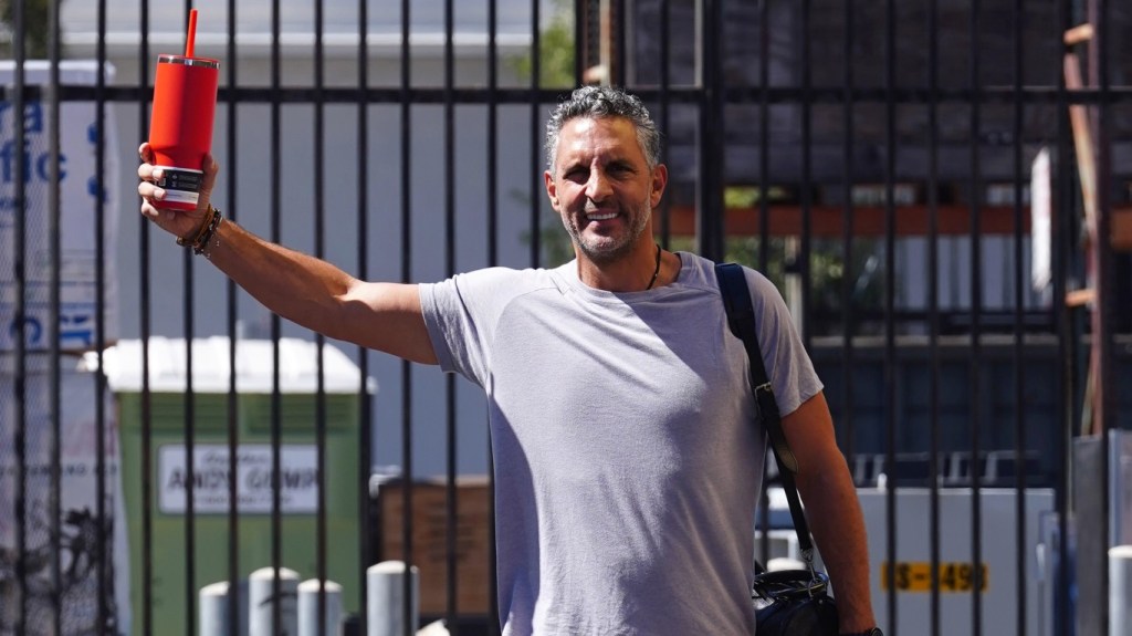 Mauricio Umansky in a grey t-shirt holding up a red cup