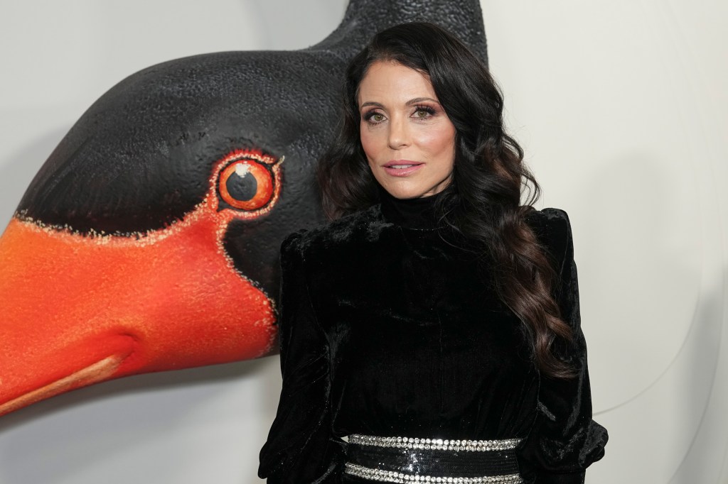 Bethenny Frankel standing in front of a black swan.
