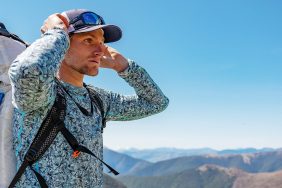 Corry Jones holding his head and looking over a cliff on Race to Survive: New Zealand