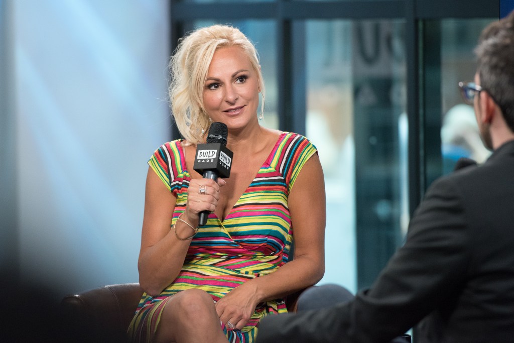 Dance Moms star Christi Lukasiak in a striped dress holding a microphone, who has been arrested for a DUI