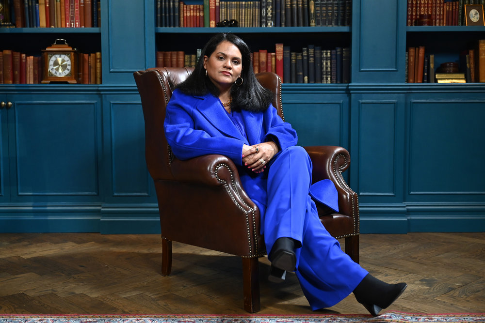 Sandra Diaz-Twine in a blue suit sitting with her legs crossed on the Traitors