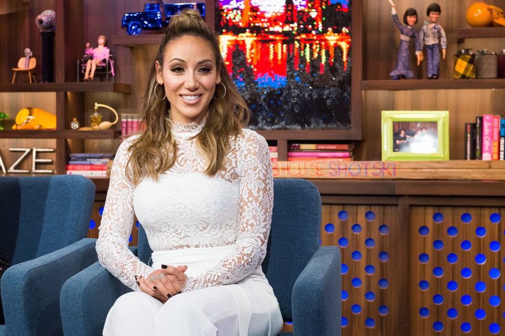 Melissa Gorga in a white outfit and smiling on WWHL.