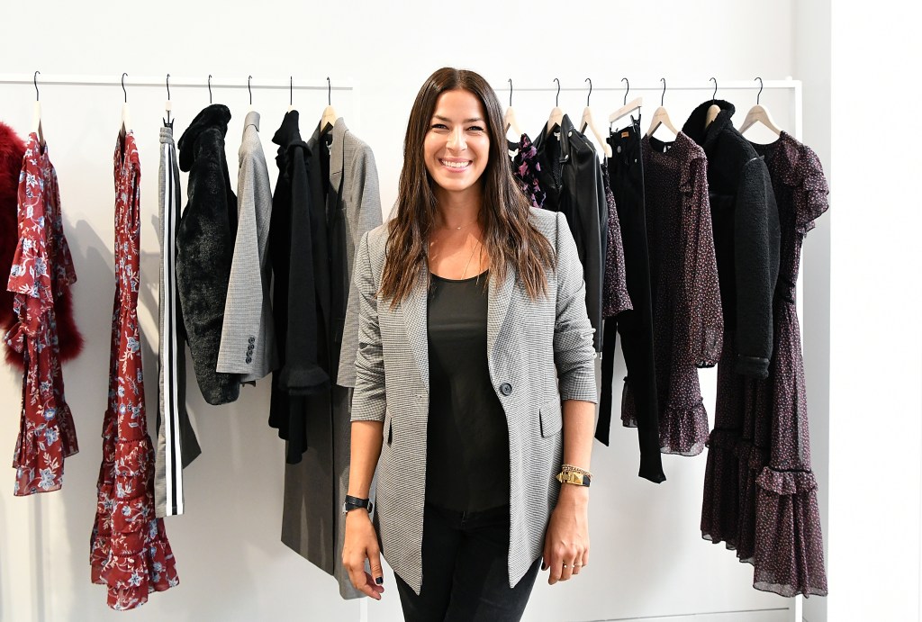 RHONY's Rebecca Minkoff standing in front of a clothing rack.