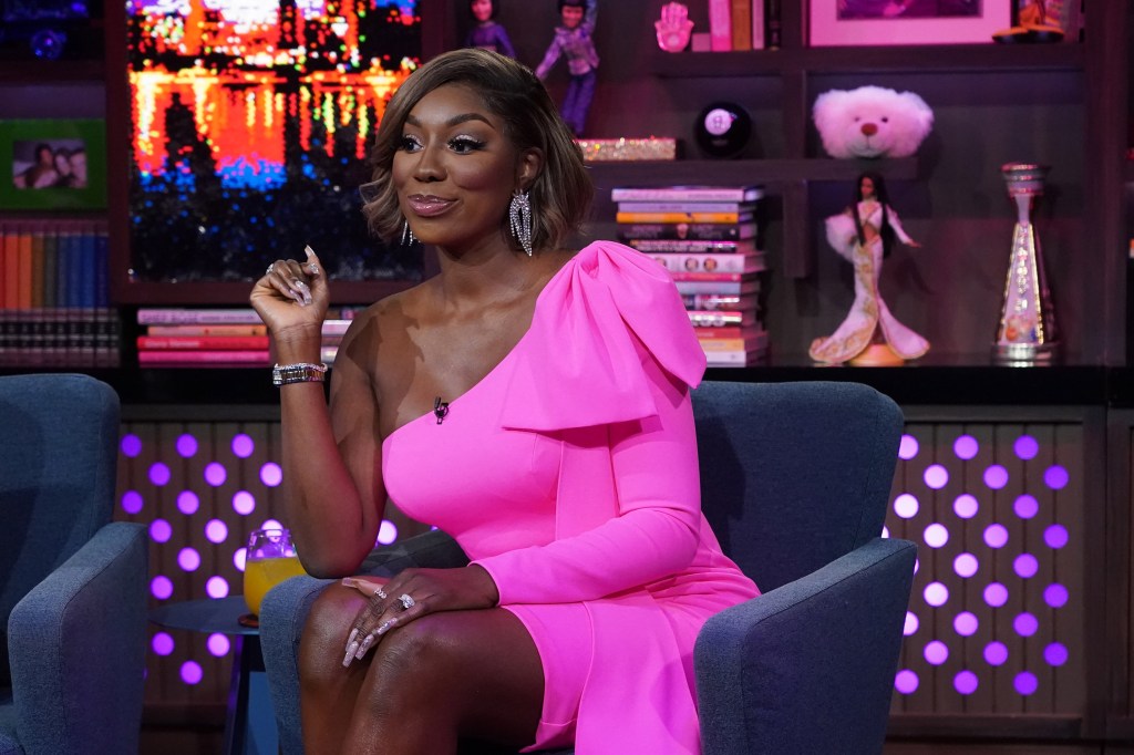 Wendy Osefo on Watch What Happens Live, smiling and wearing a pink dress