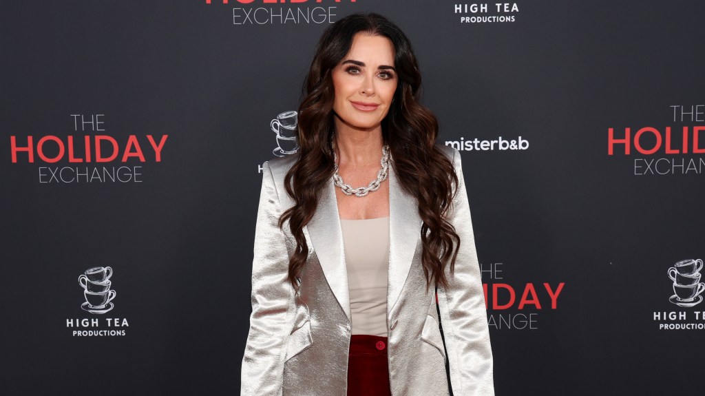 Kyle Richards in a white satin blazer at an event.