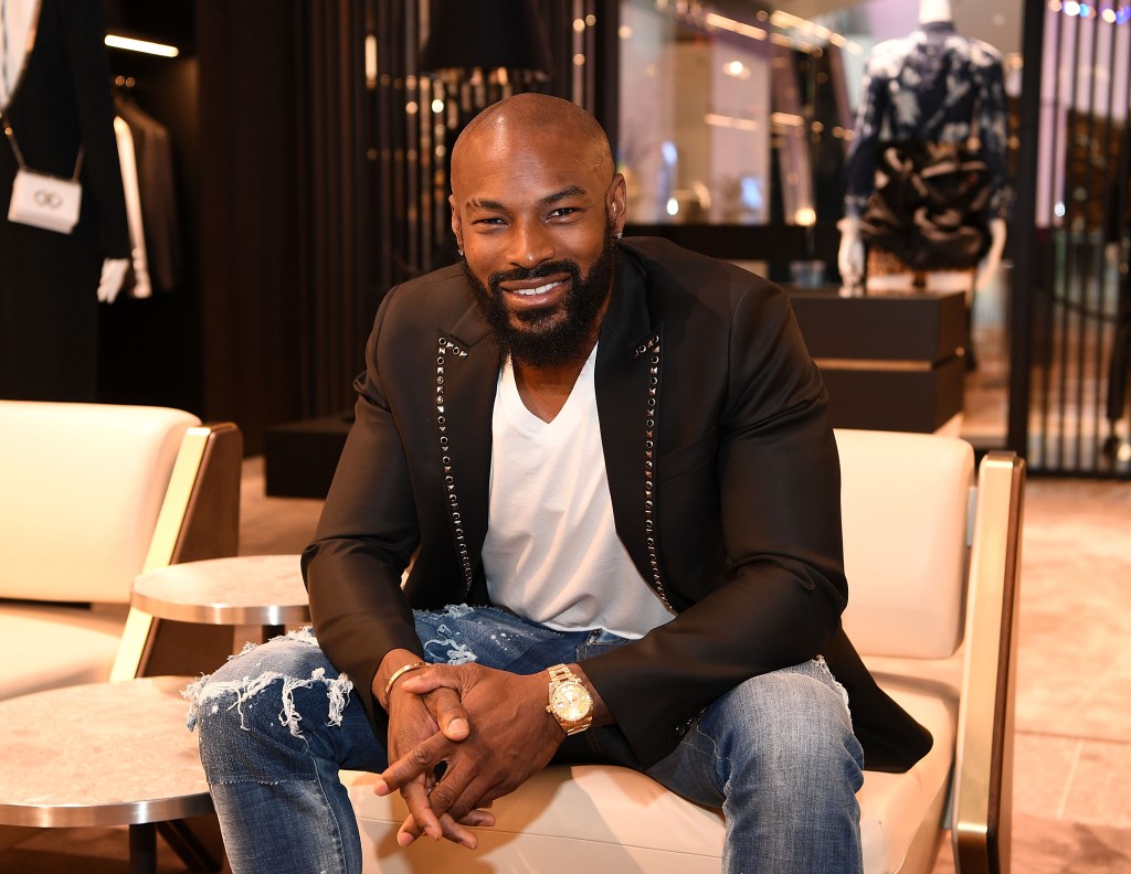 Tyson Beckford sitting in a chair and wearing jeans and a black blazer