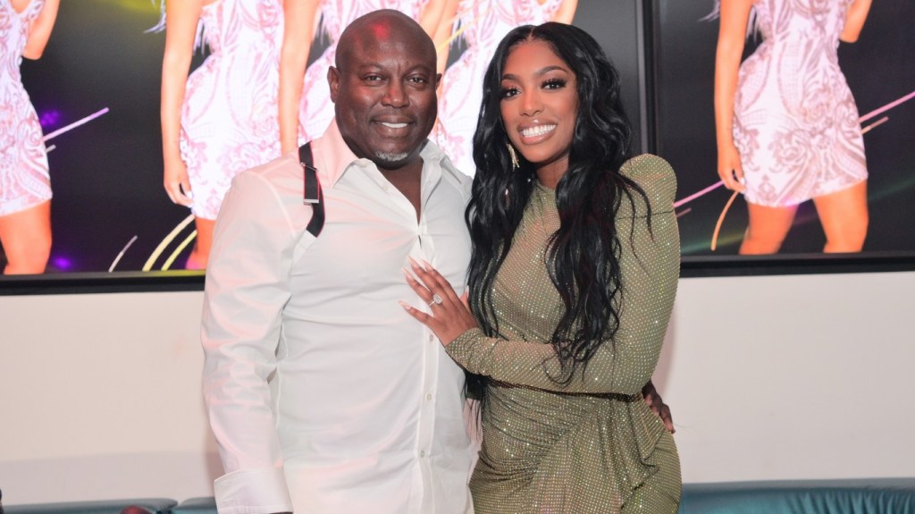 Simon Guobadia and Porsha Williams posing together at a party, she has her hand on his chest