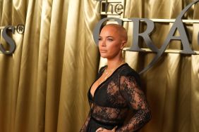 Teddi Mellencamp in a lacy, black dress standing in front of a gold curtain